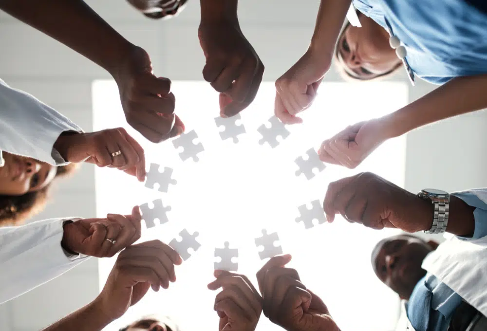 Circle of people holding puzzle pieces